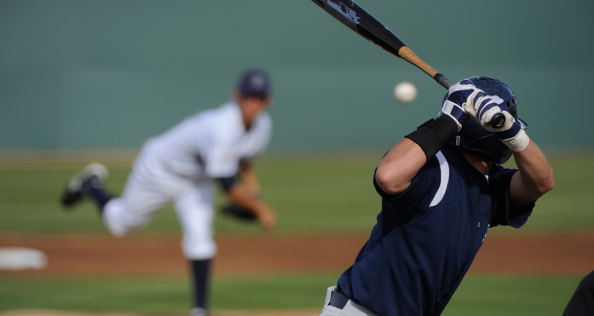 A baseball player hitting a ball with a bat.