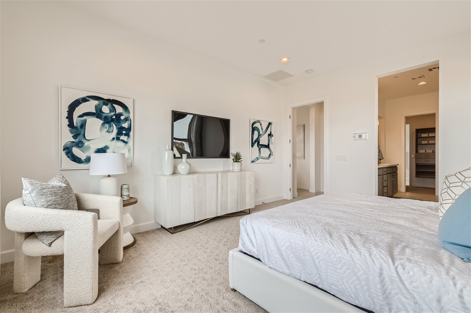 A bedroom with a bed and a chair.