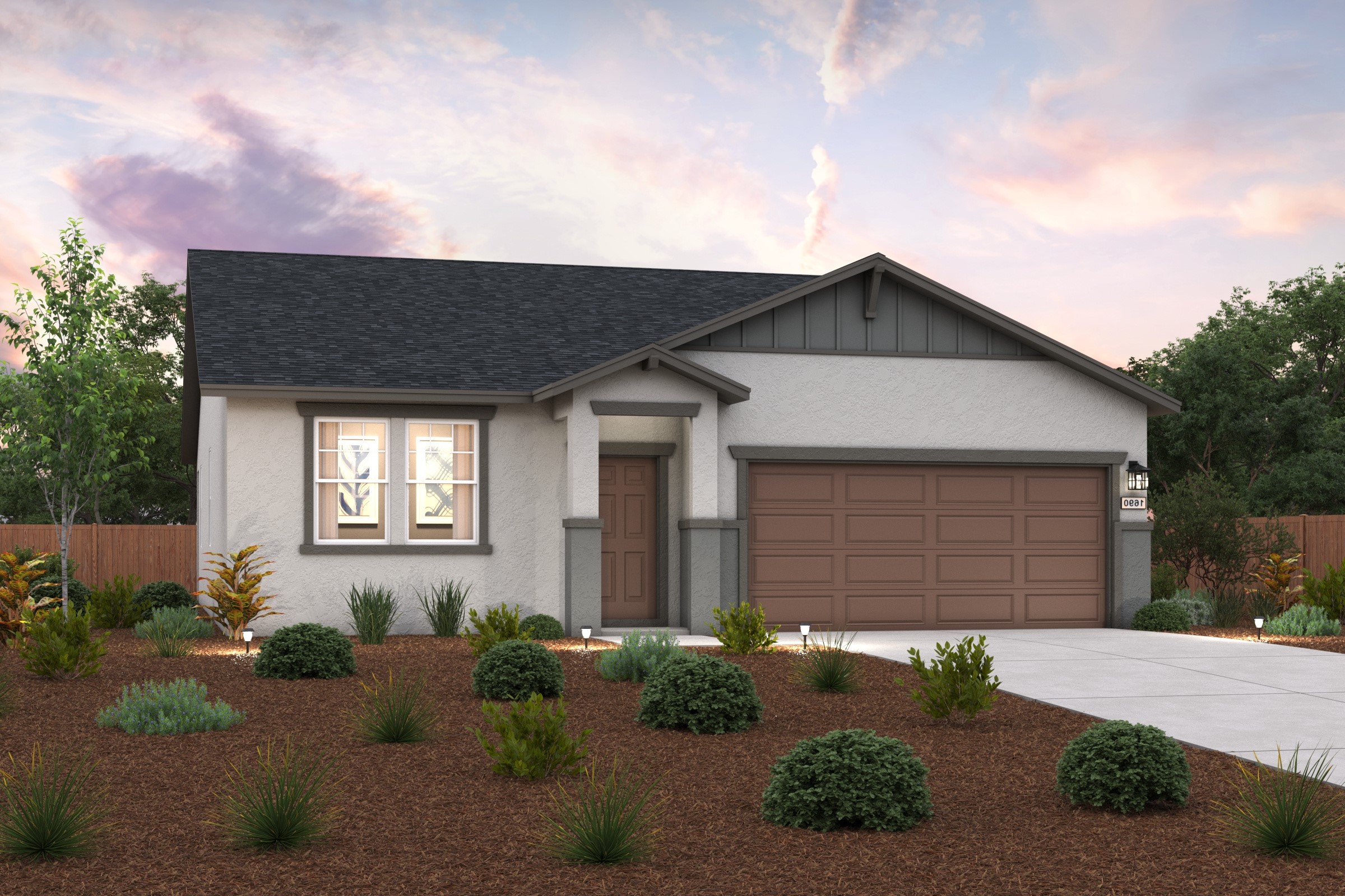 A house with a garage and bushes in front of it.