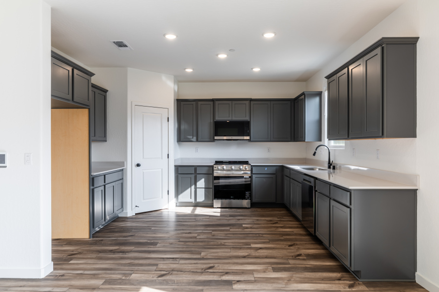 A kitchen with black cabinets.