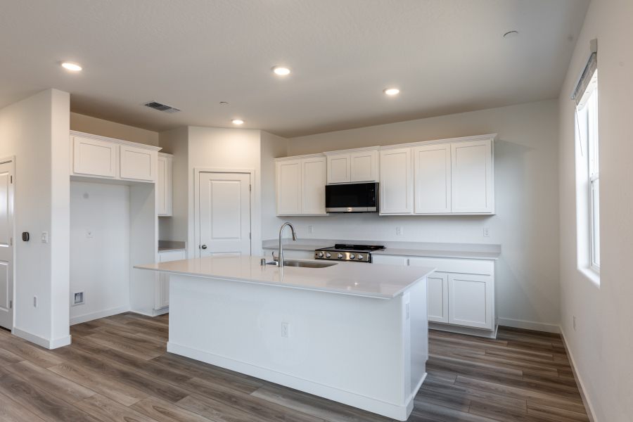 A kitchen with white cabinets.
