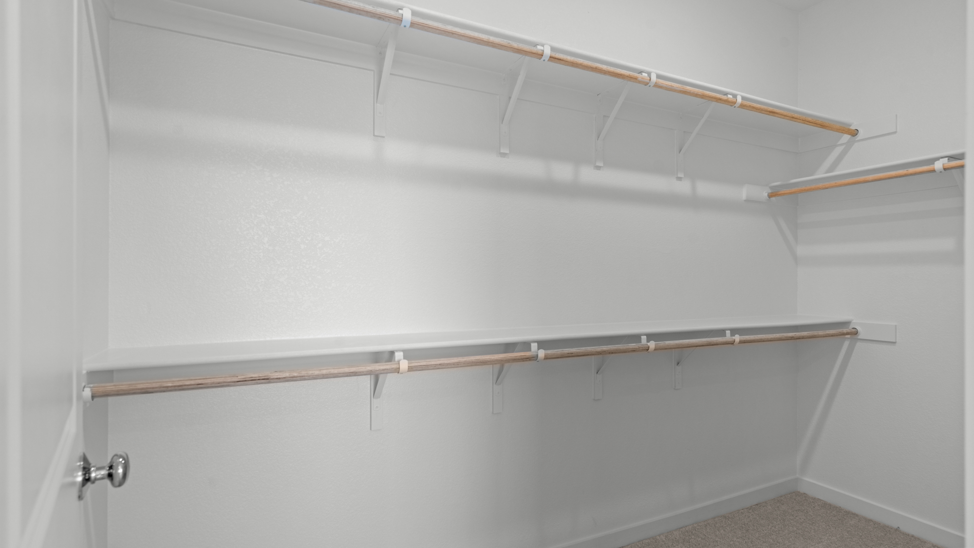 A white wall with a metal bar.