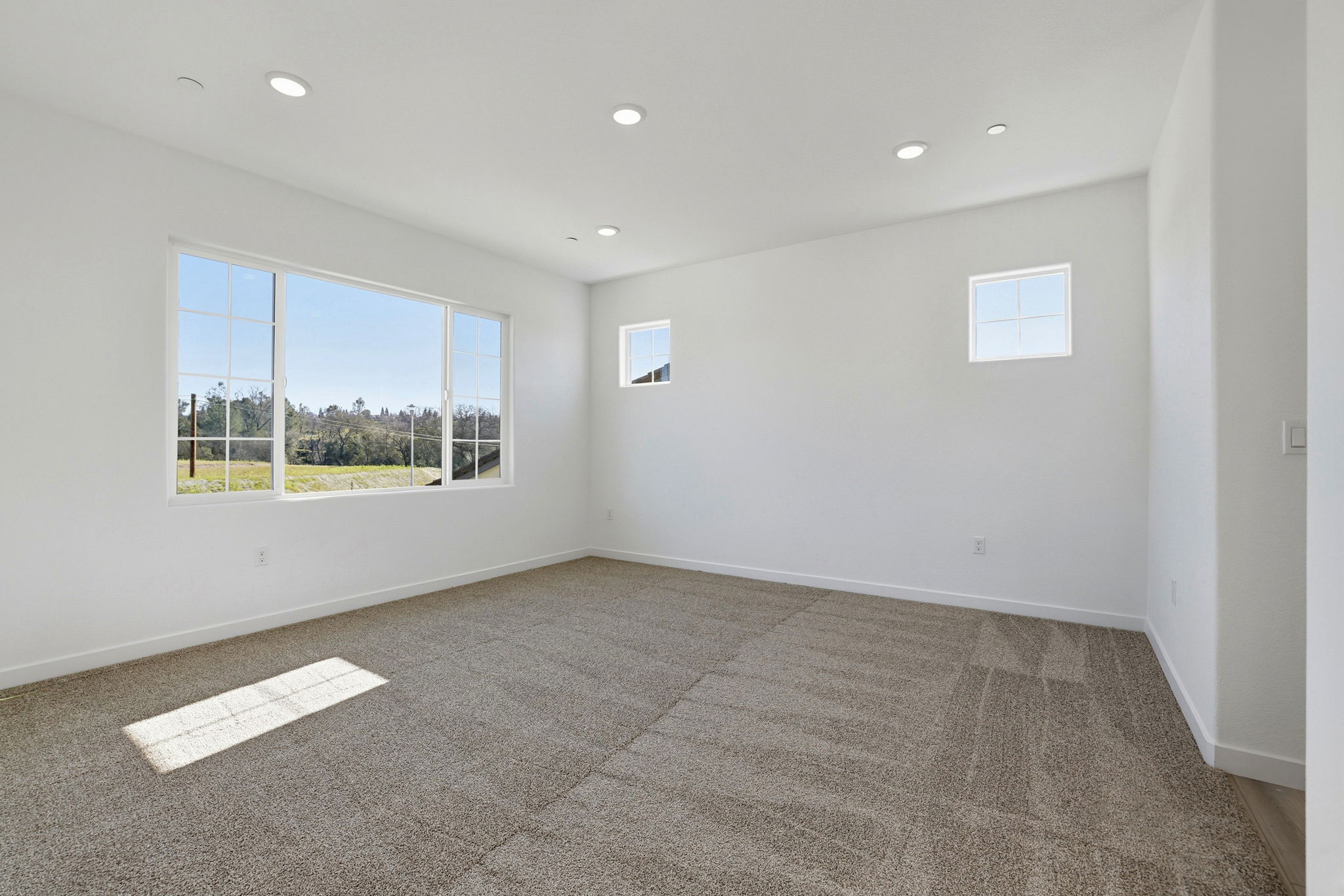 A room with a window and a carpet.