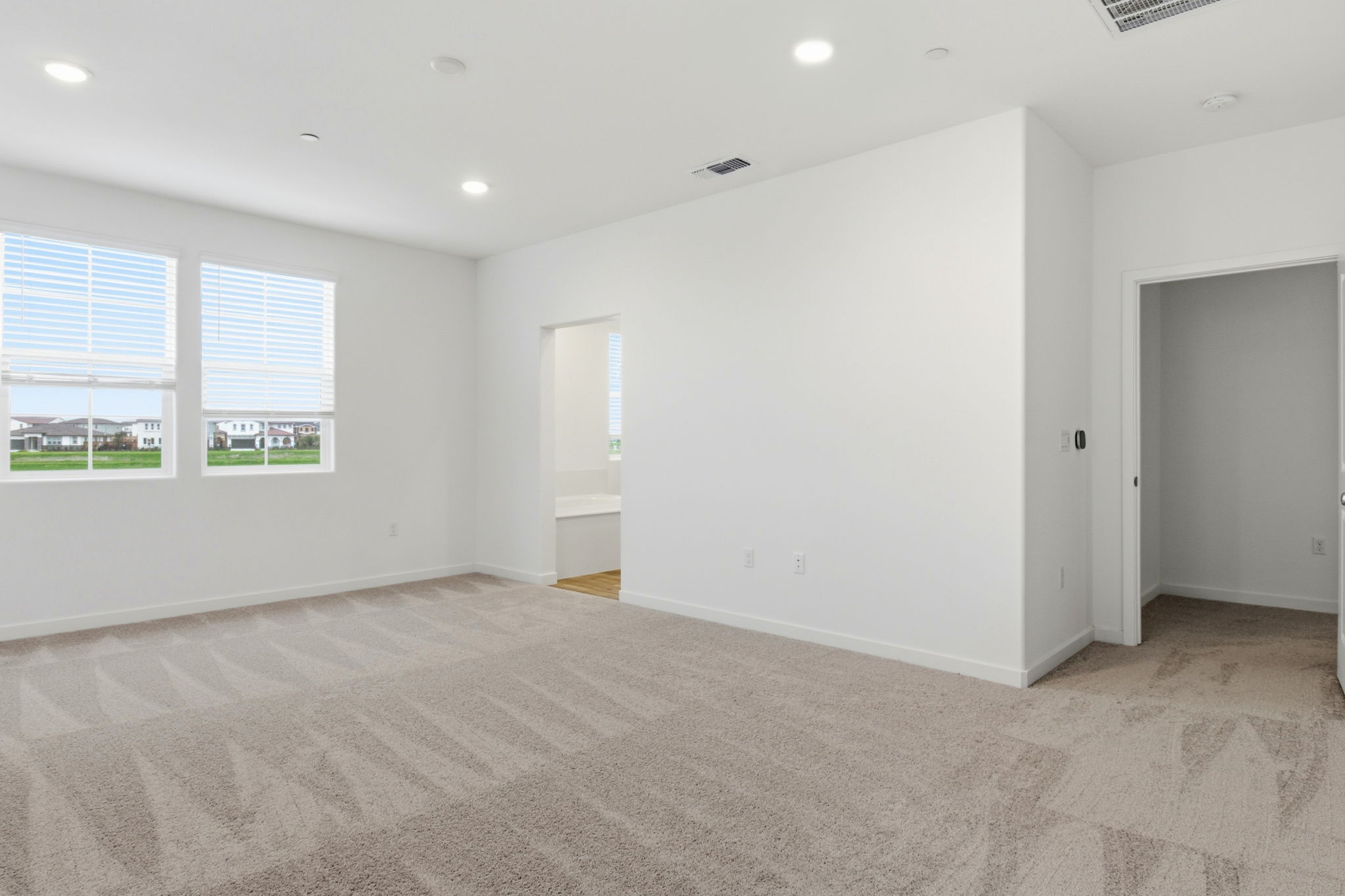 A room with a carpet and windows.