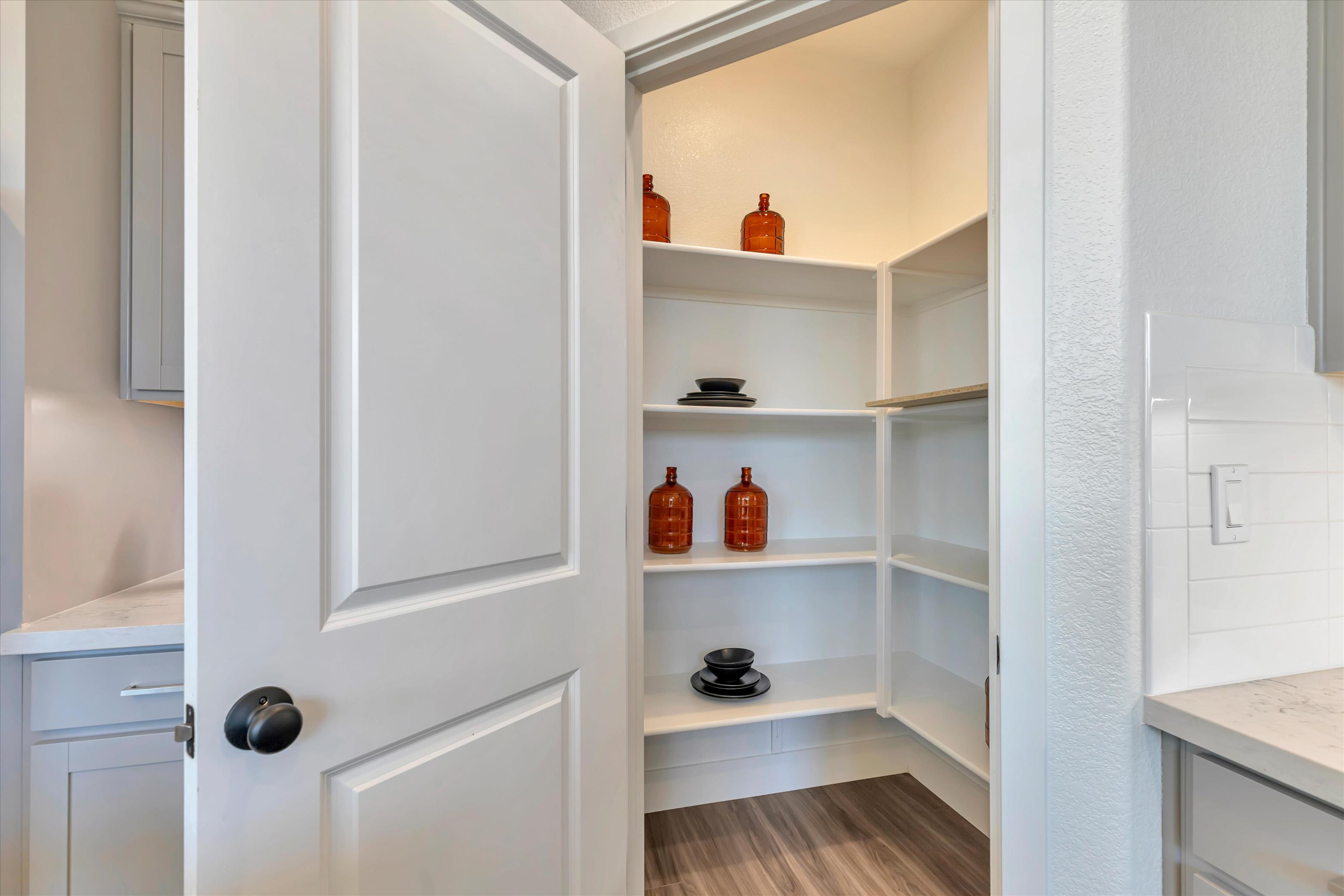 A white shelving unit with white cabinets.
