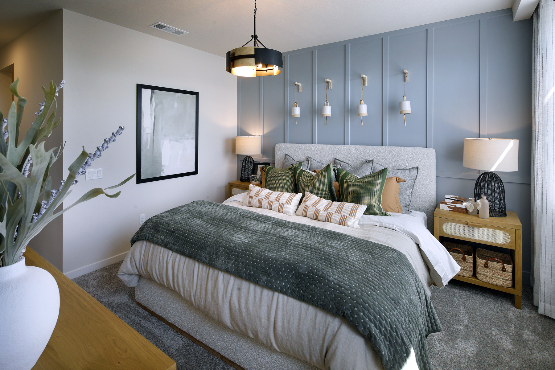 A bedroom with a bed and lamps.