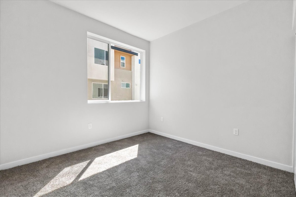 A room with a window and a carpet.