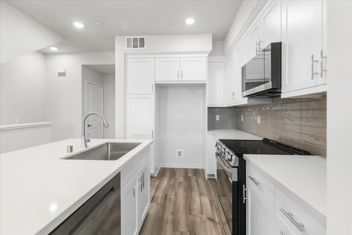 A kitchen with white cabinets.