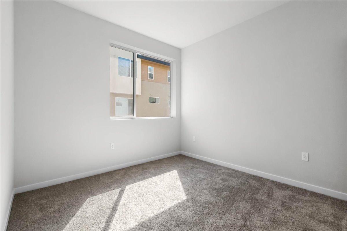 A room with a window and a rug.
