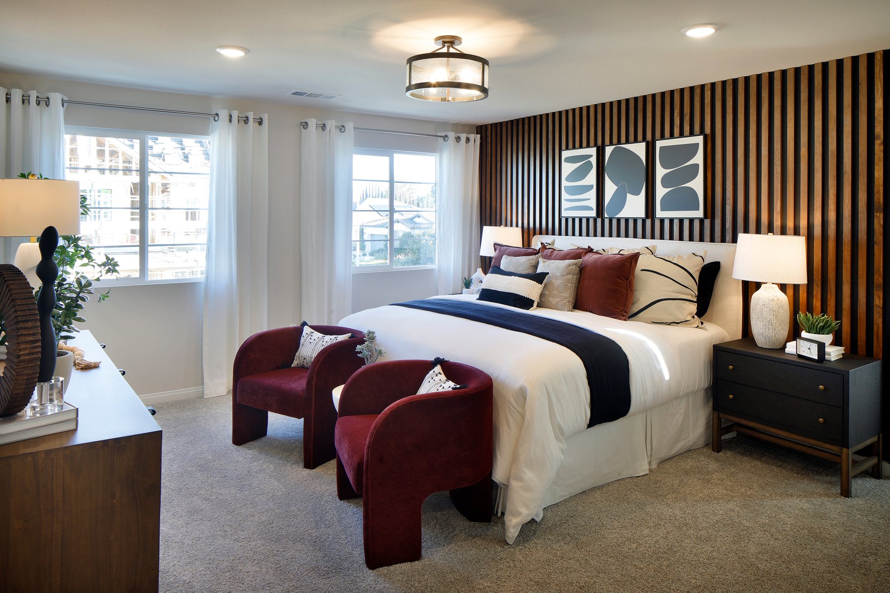 A bedroom with a bed and chairs.