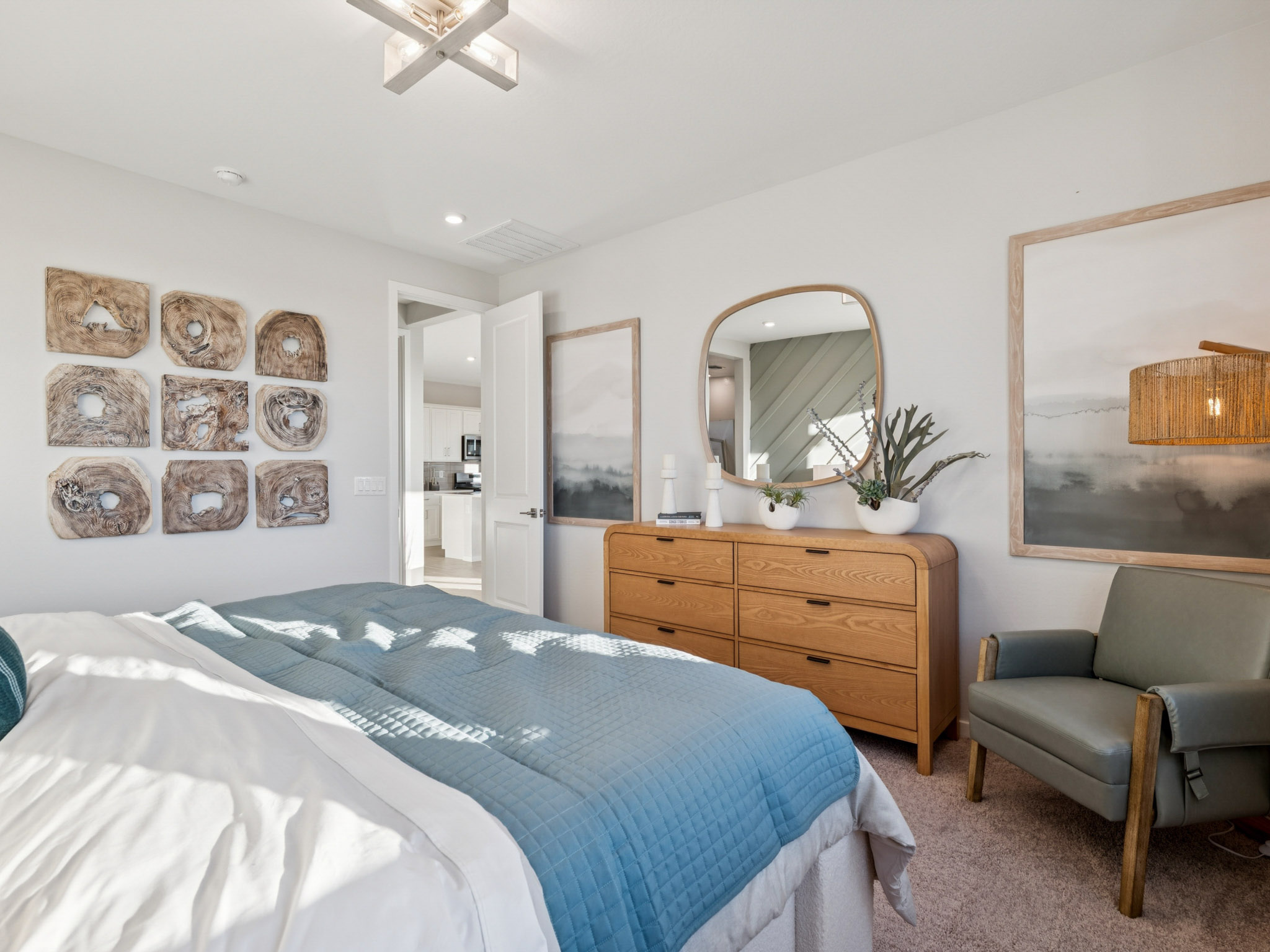 Bedroom Primary suite at new coming soon community at Mission Ranch in Casa Grande AZ with elegant dresser, chair, and beding.