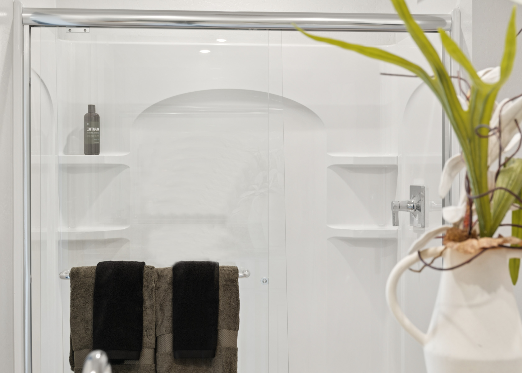 A shower with a plant in it.