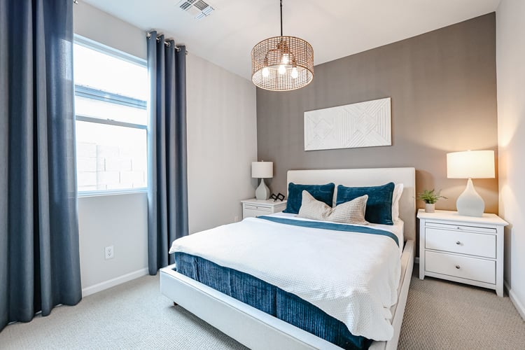 A bedroom with a bed and lamps.