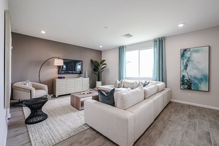 A living room with a white couch and a tv.