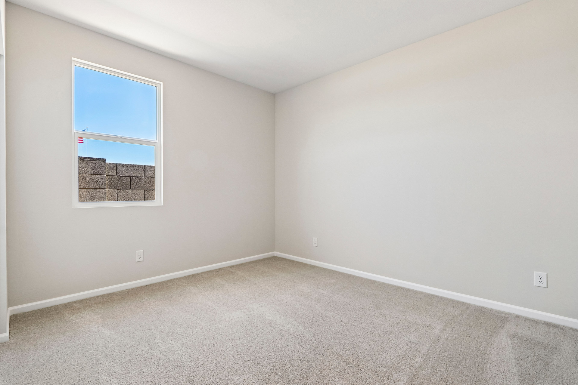 A room with a window and a rug on the floor.