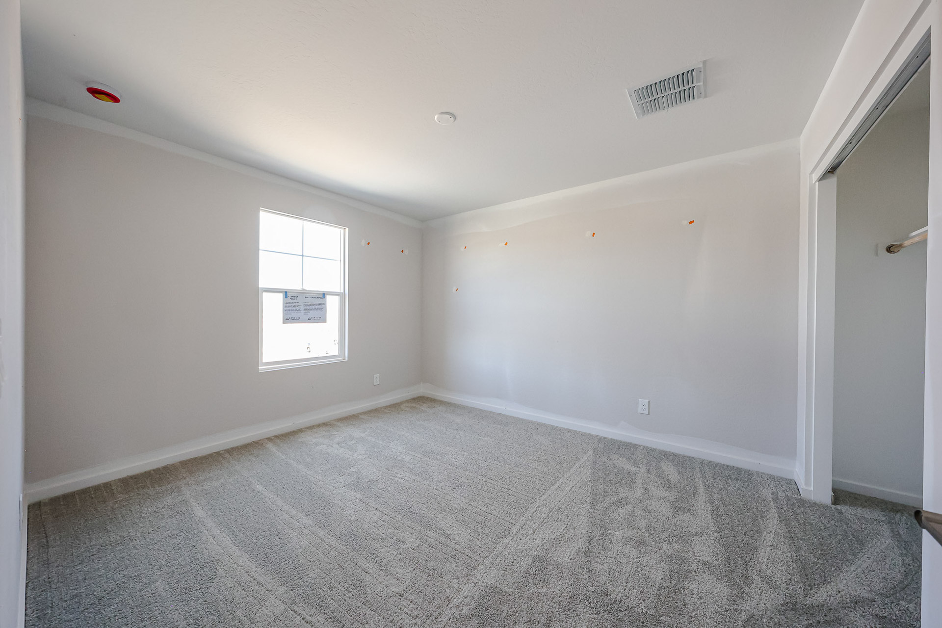 A room with a carpet and a window.
