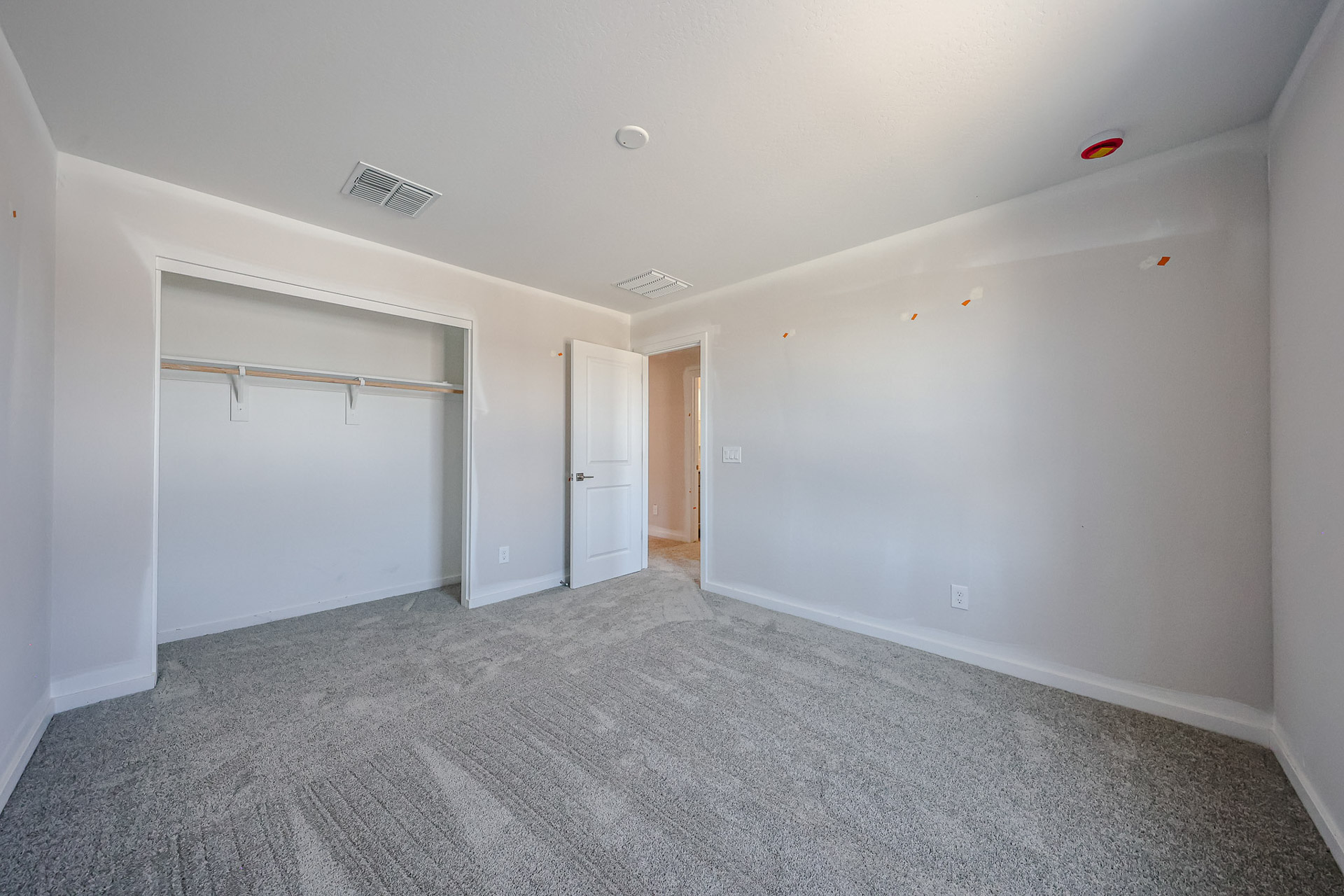 A room with a carpet and a door.