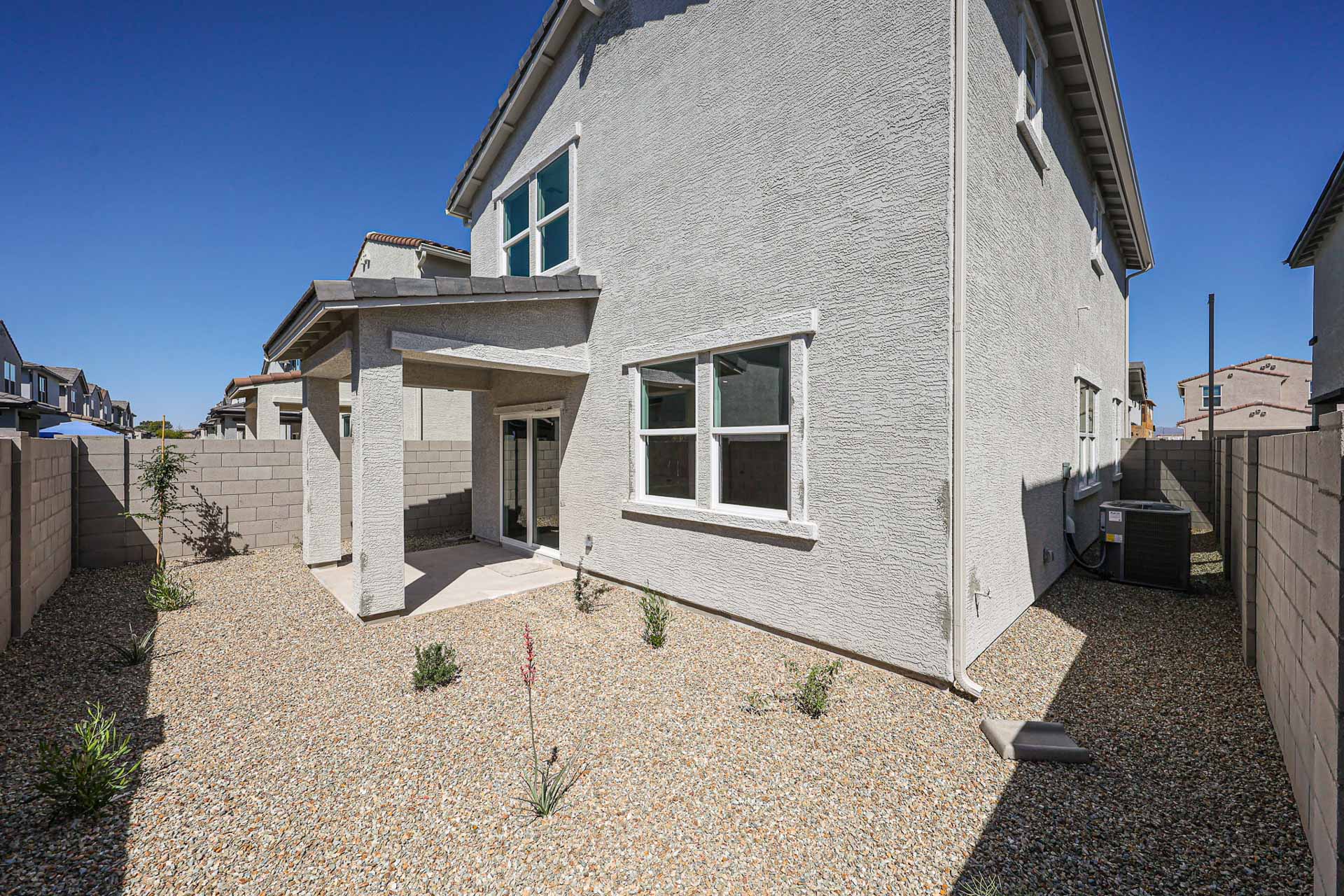A white house with a stone patio.