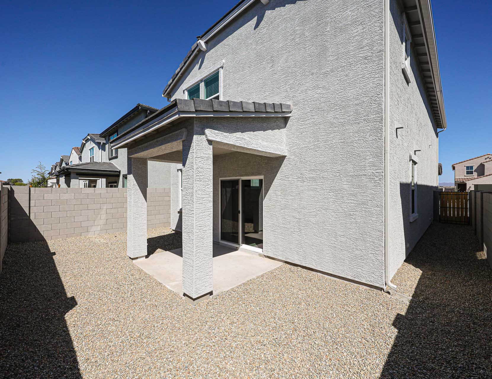 A white house with a stone wall.