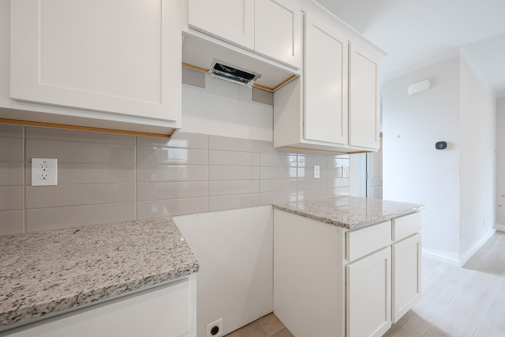 A kitchen with white cabinets.