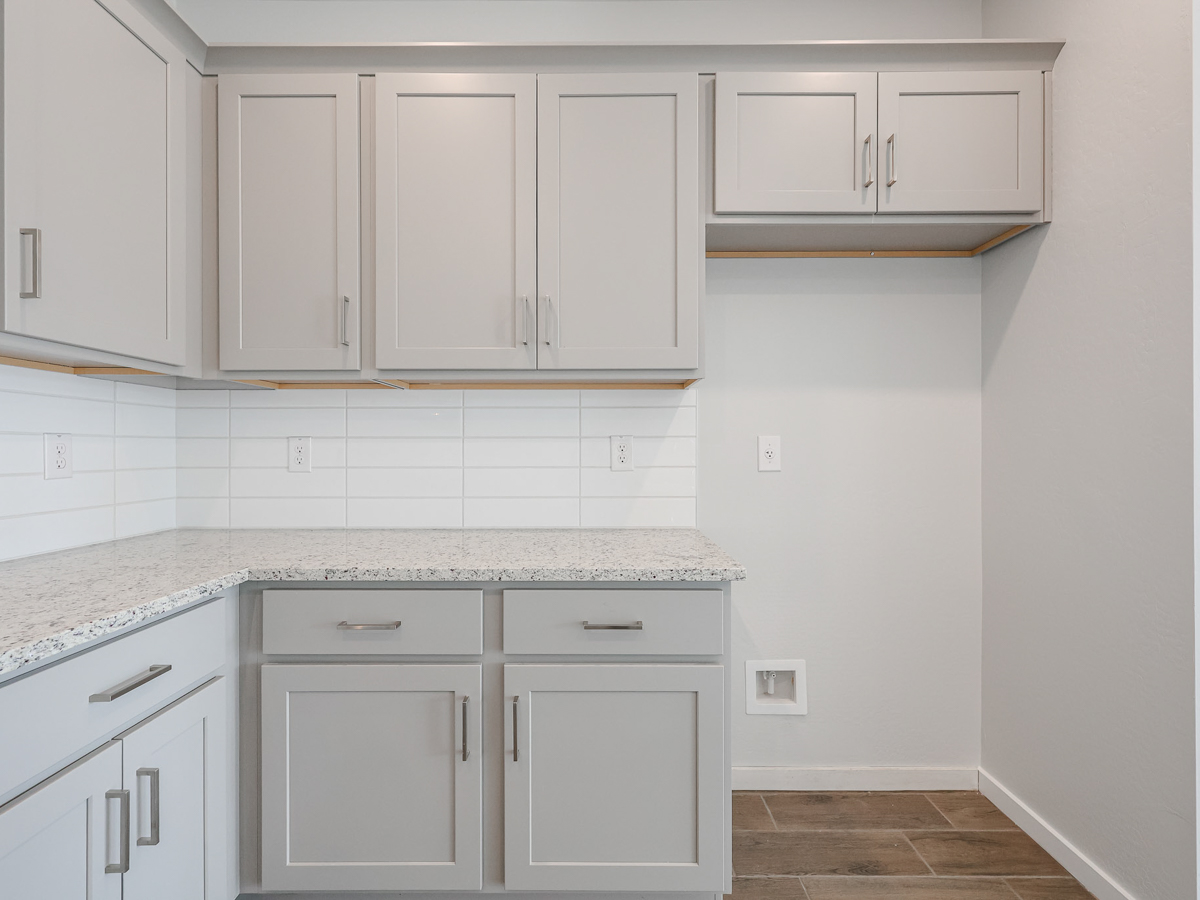 A kitchen with white cabinets.