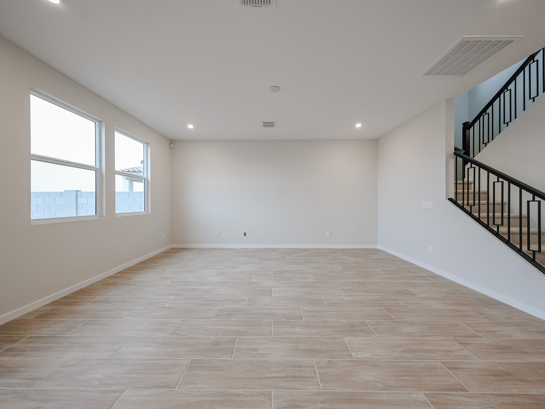 A room with a staircase and windows.