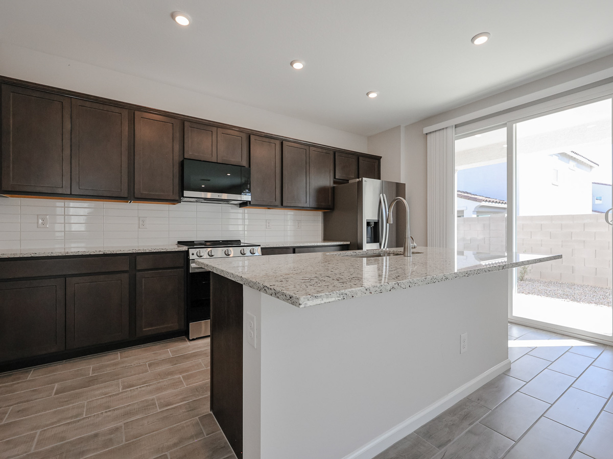 A kitchen with a marble counter top.