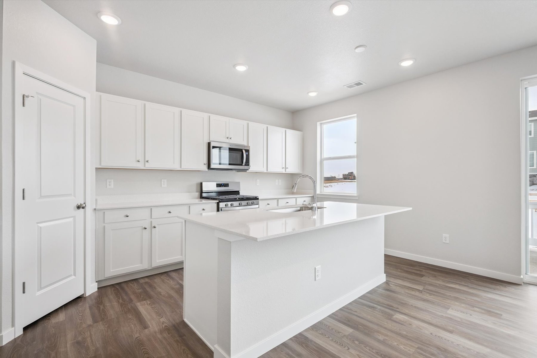 A kitchen with white cabinets.
