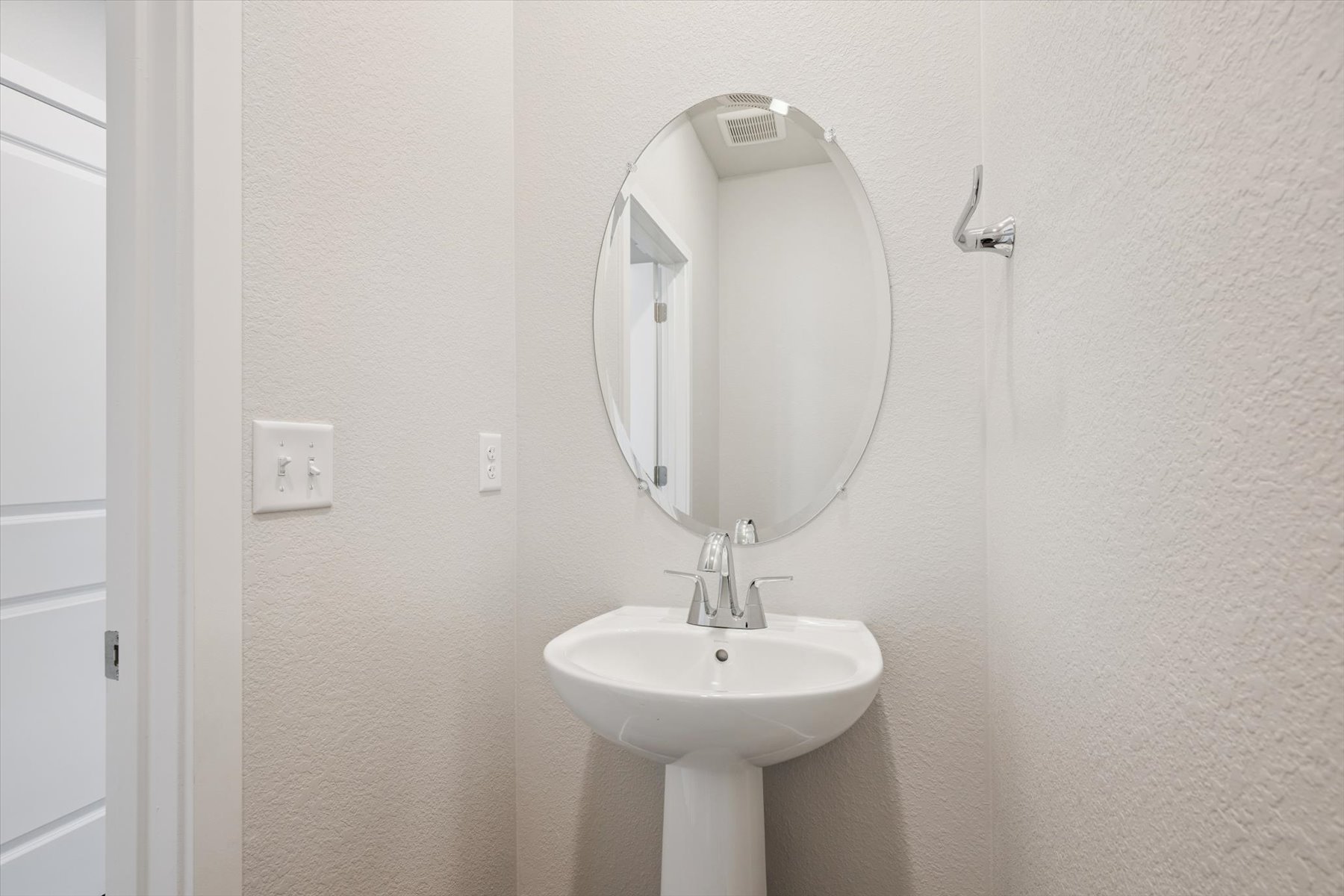 A bathroom with a round mirror.