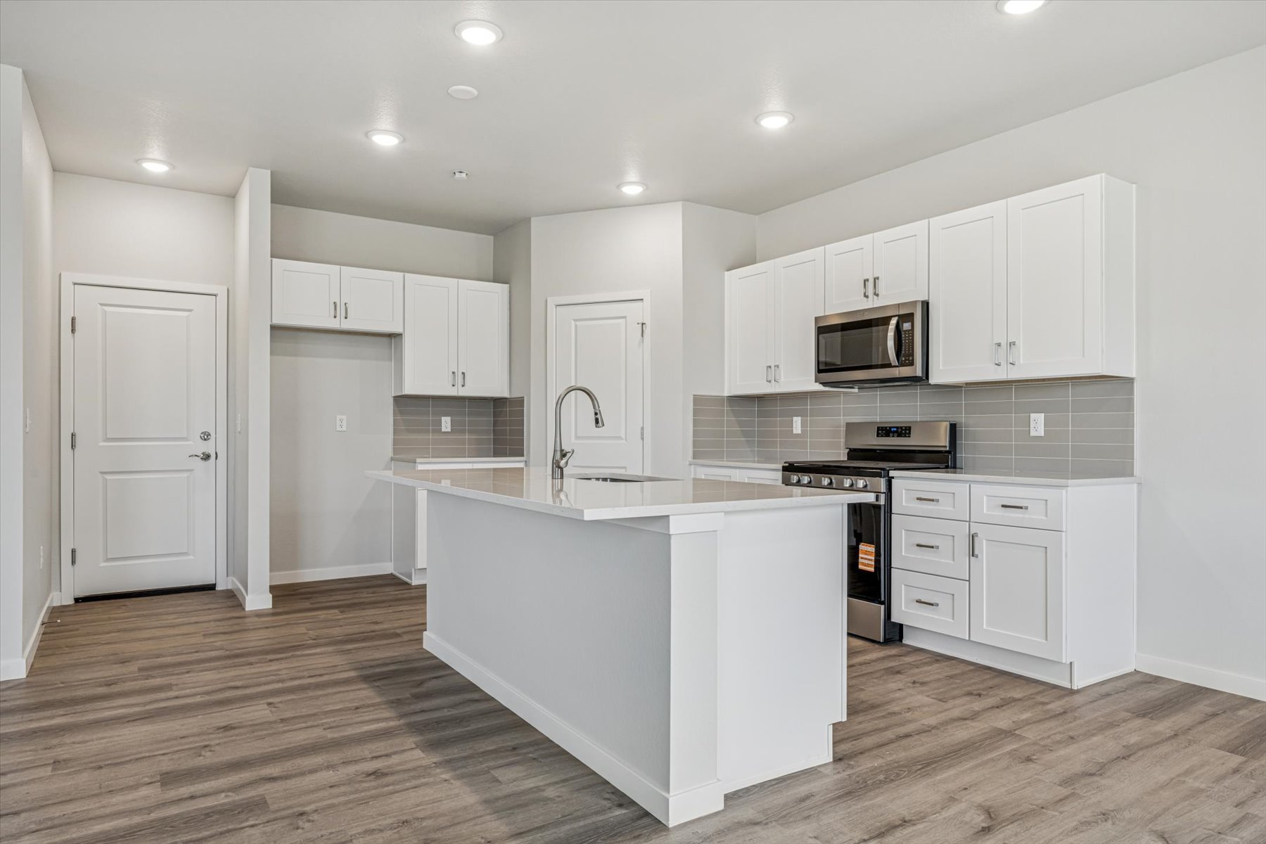 A kitchen with white cabinets.