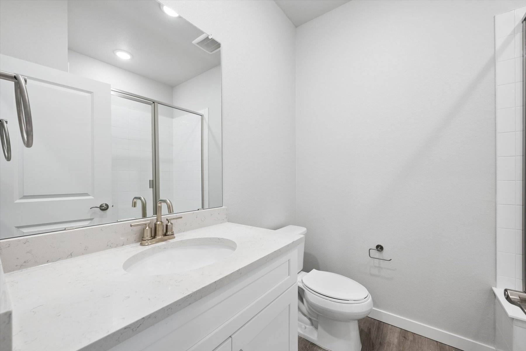 A bathroom with a sink toilet and mirror.