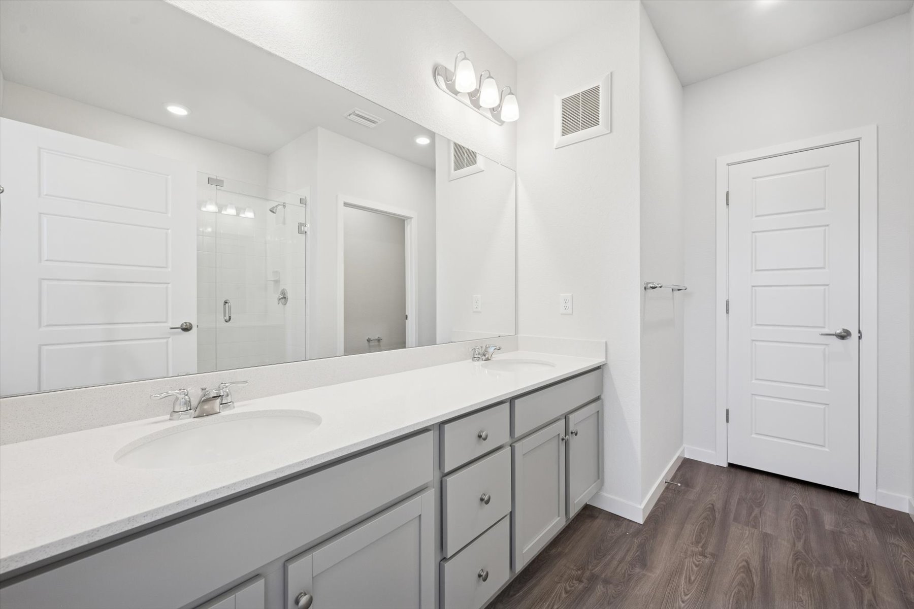 A bathroom with white cabinets.