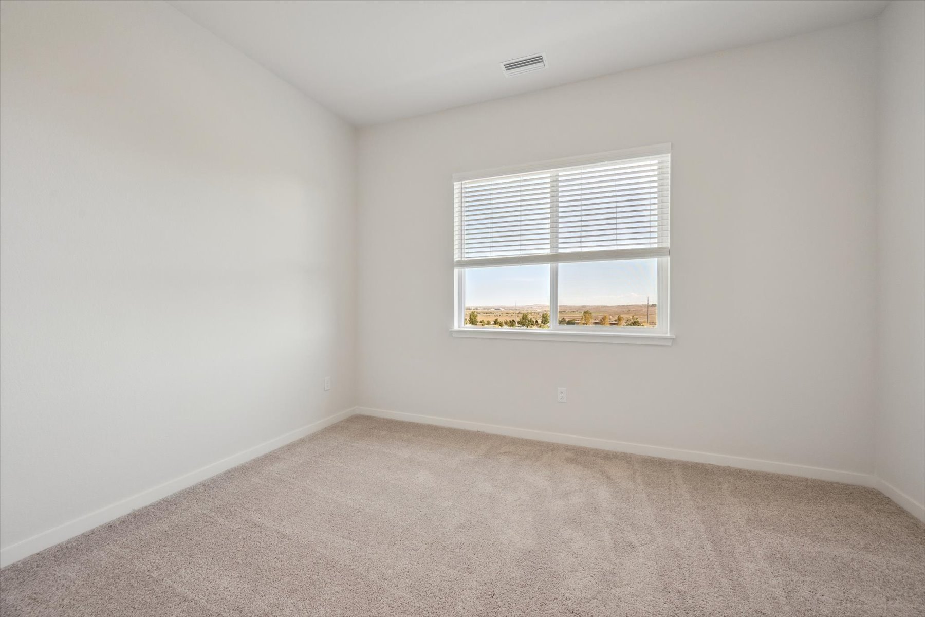 A room with a window and carpet.