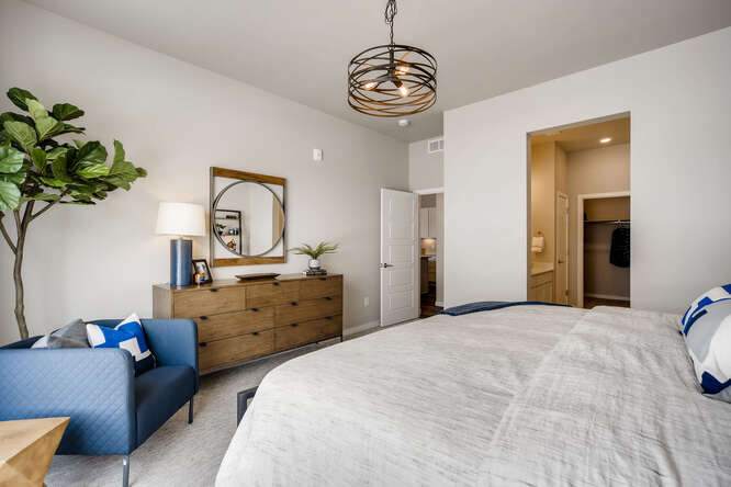 A bedroom with a bed and a mirror.