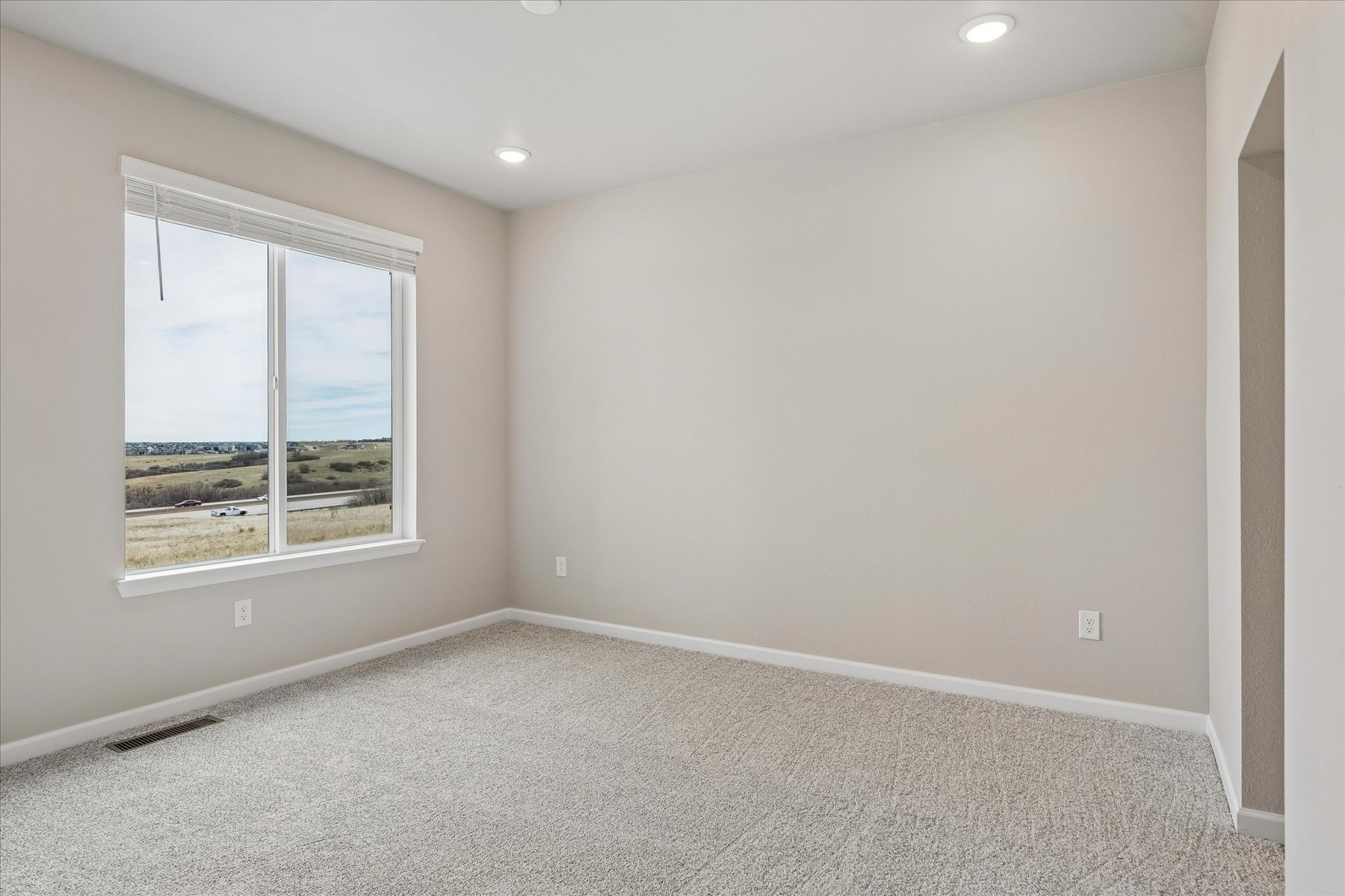 A room with a window and a carpet.