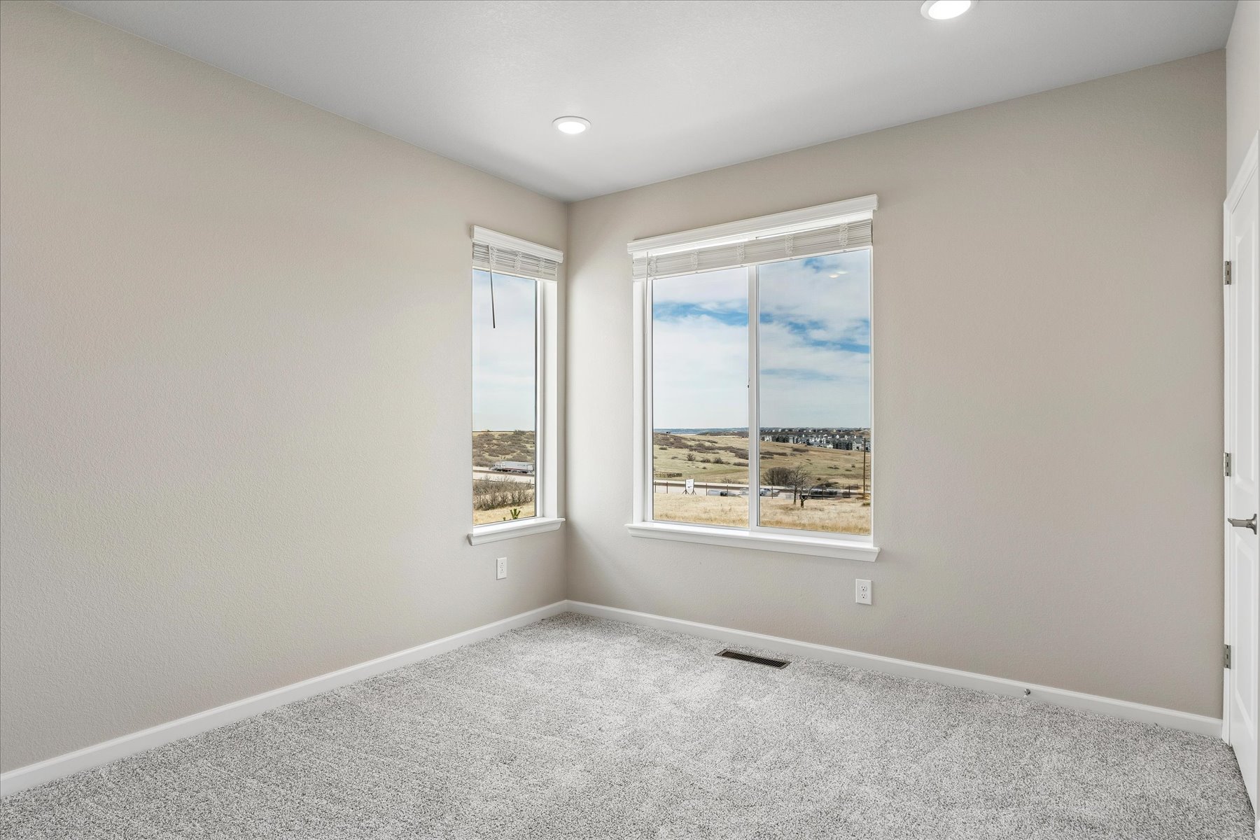 A room with a window and a rug.