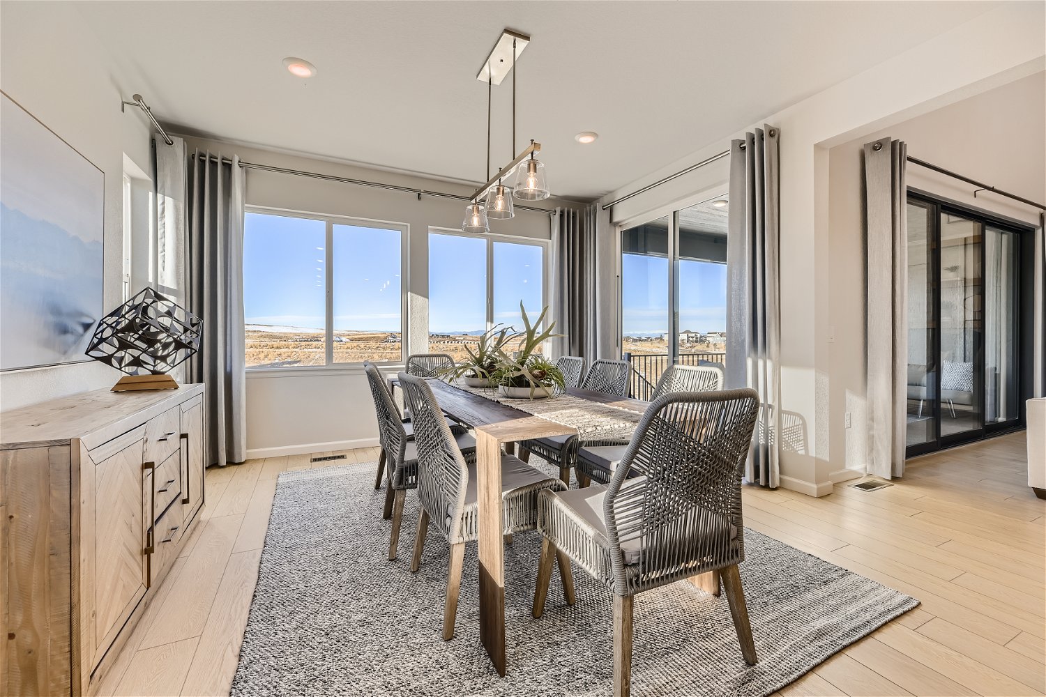 A dining room with a chandelier and a table with chairs.