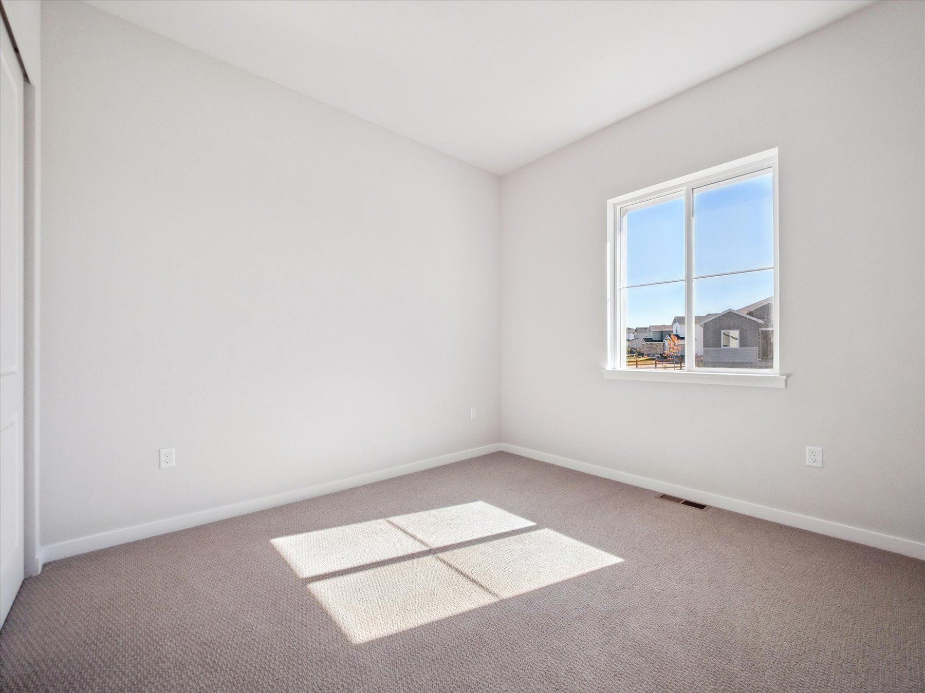 A room with a rug and a window.