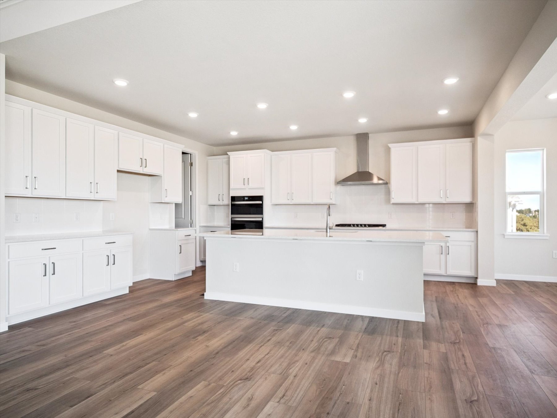A kitchen with white cabinets.
