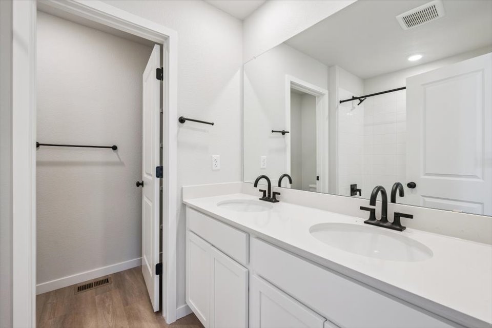 A bathroom with white cabinets.