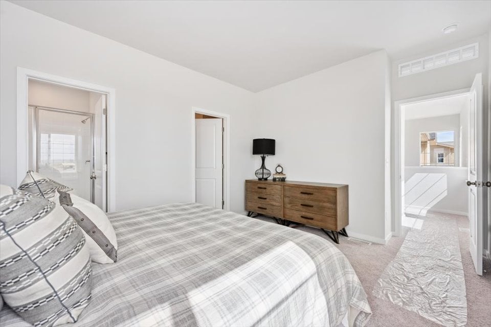 A bedroom with a bed and a dresser.