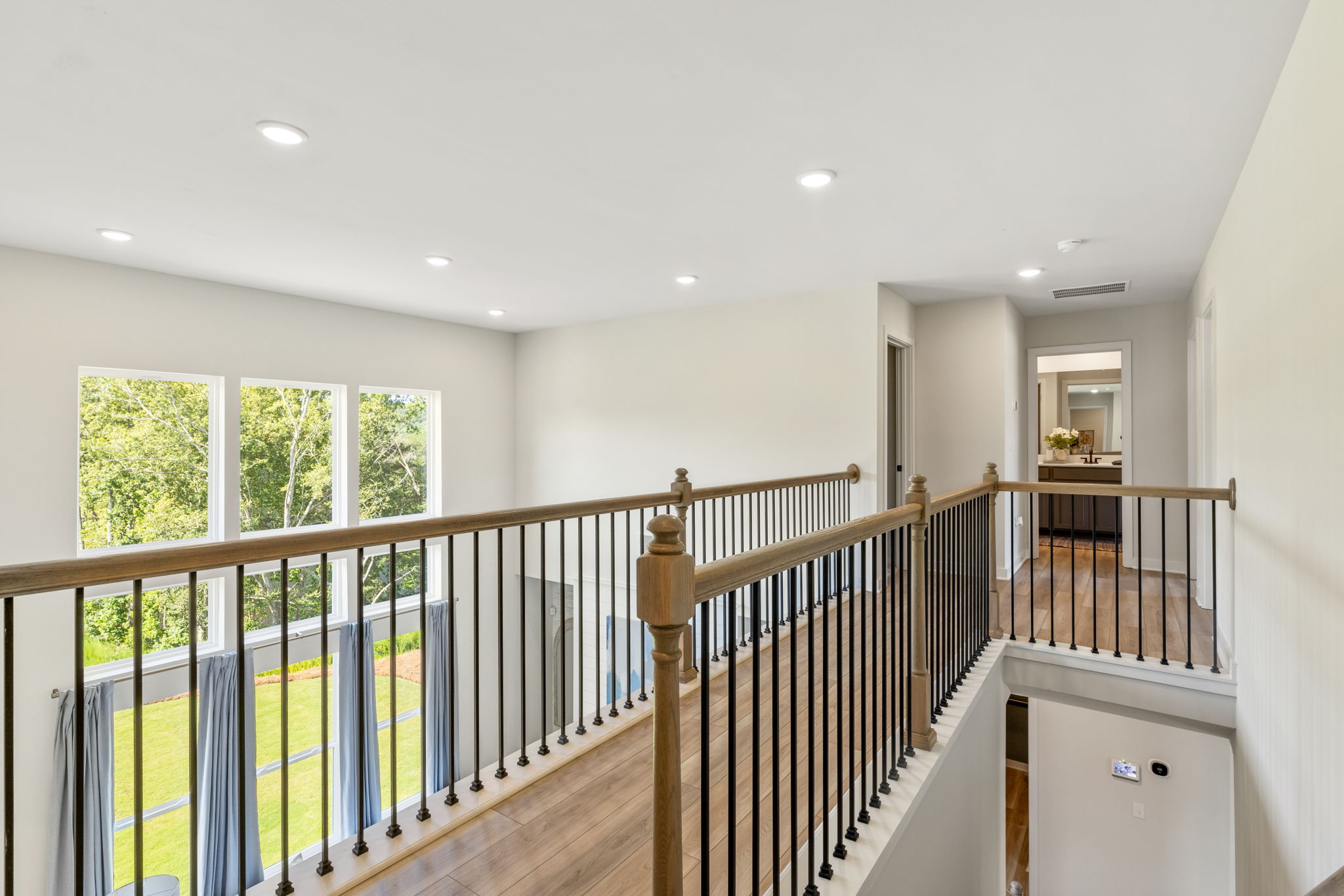 A room with a wood railing and windows.