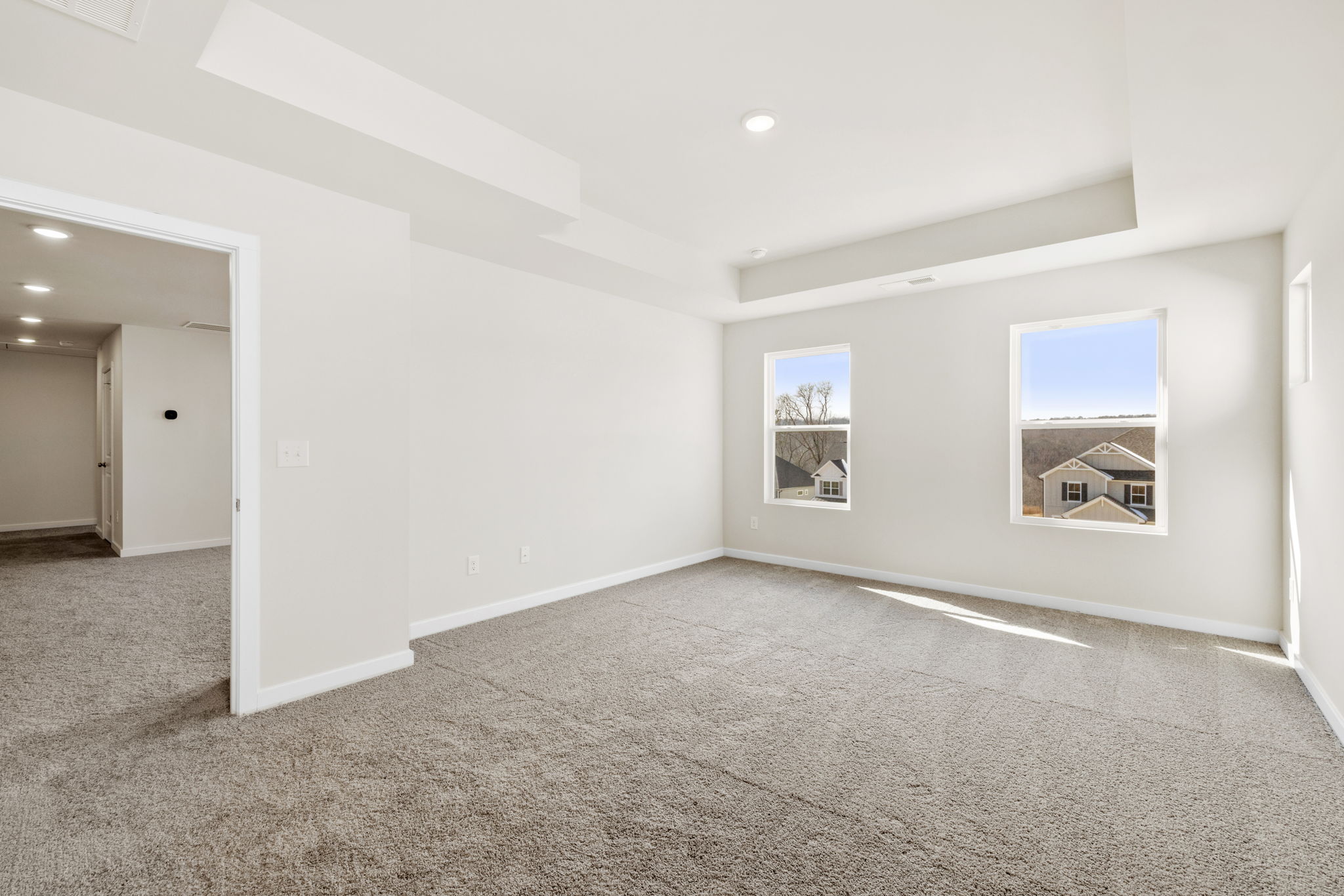 A room with a carpet and a few paintings on the wall.