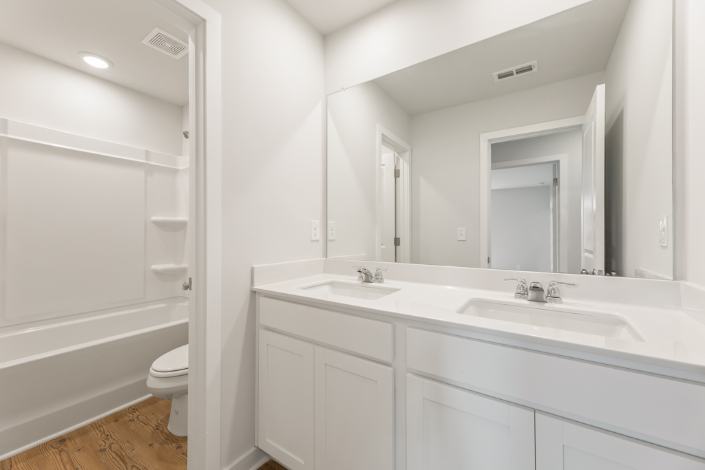 A bathroom with white cabinets.