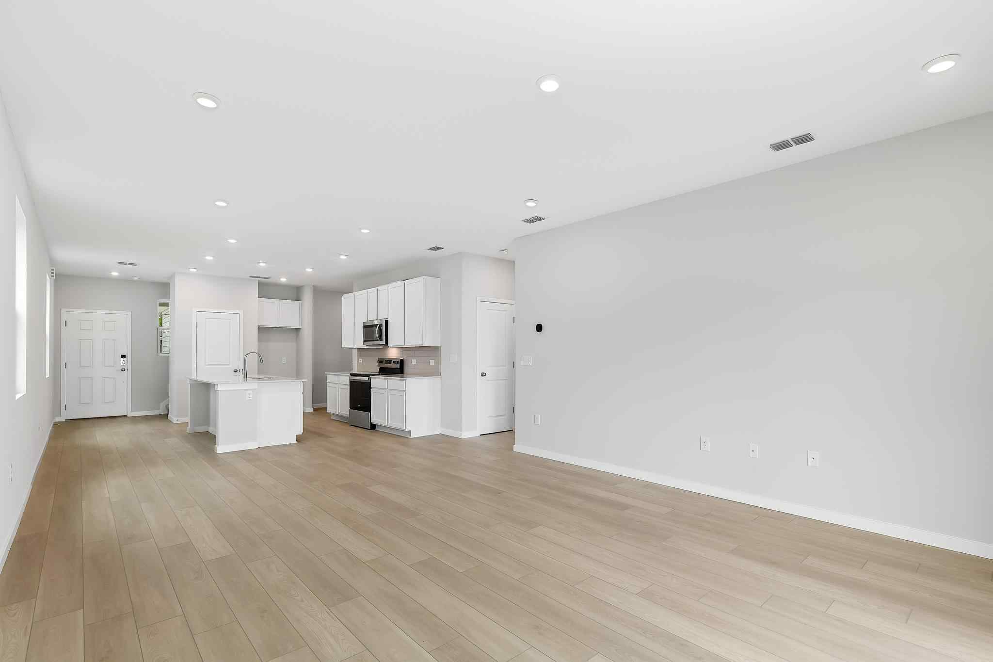 A large empty room with white cabinets.