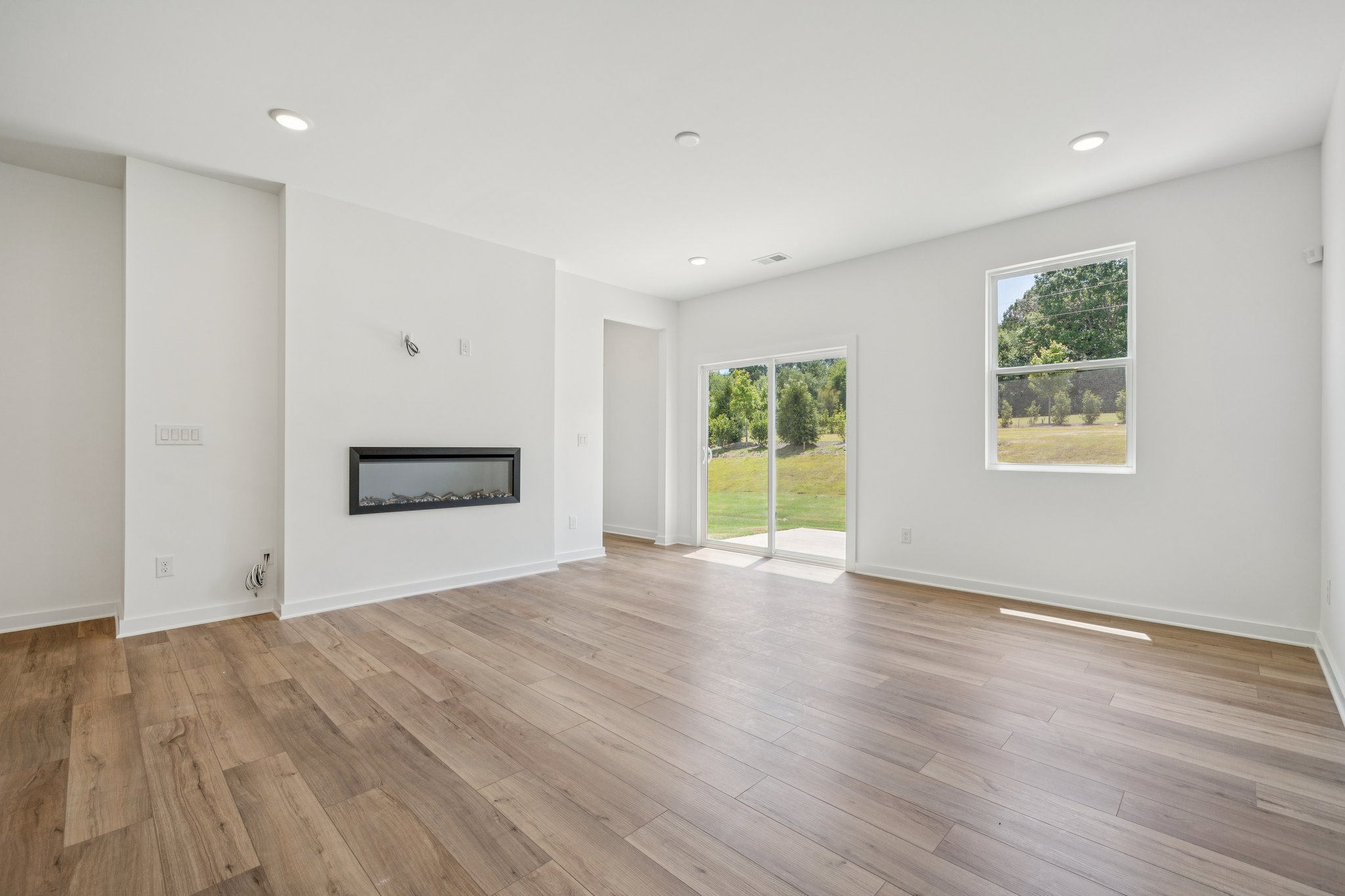 A room with white walls and a wood floor with a wood floor.