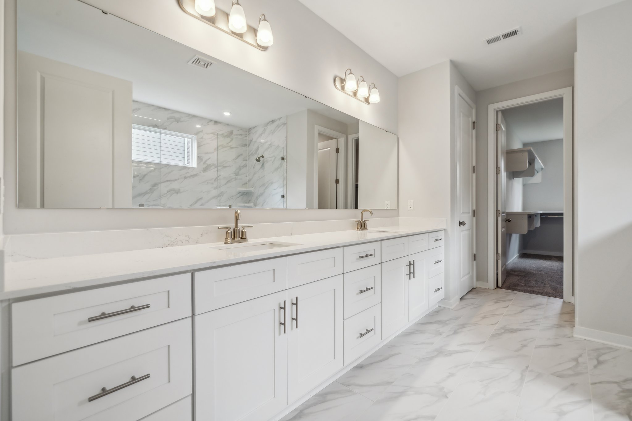 A bathroom with white cabinets.