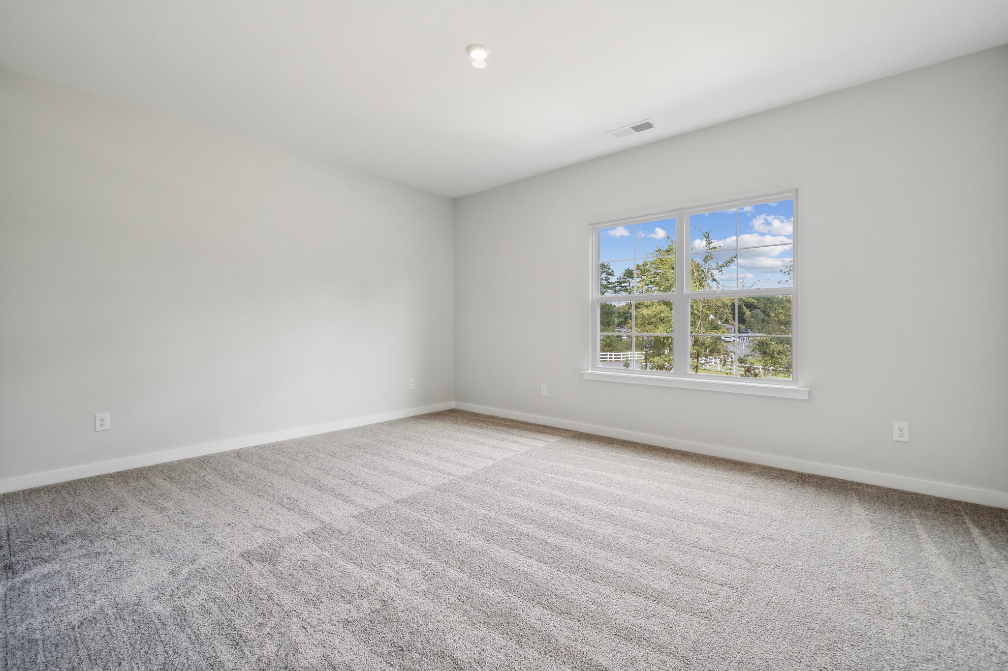 A room with a window and a carpet.