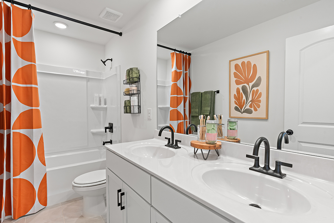 A bathroom with a sink toilet and a mirror.