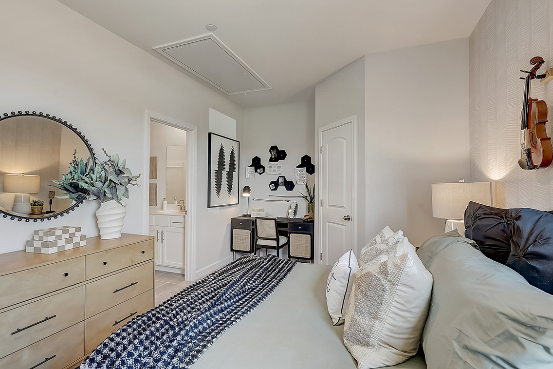 A bedroom with a mirror and a bed.